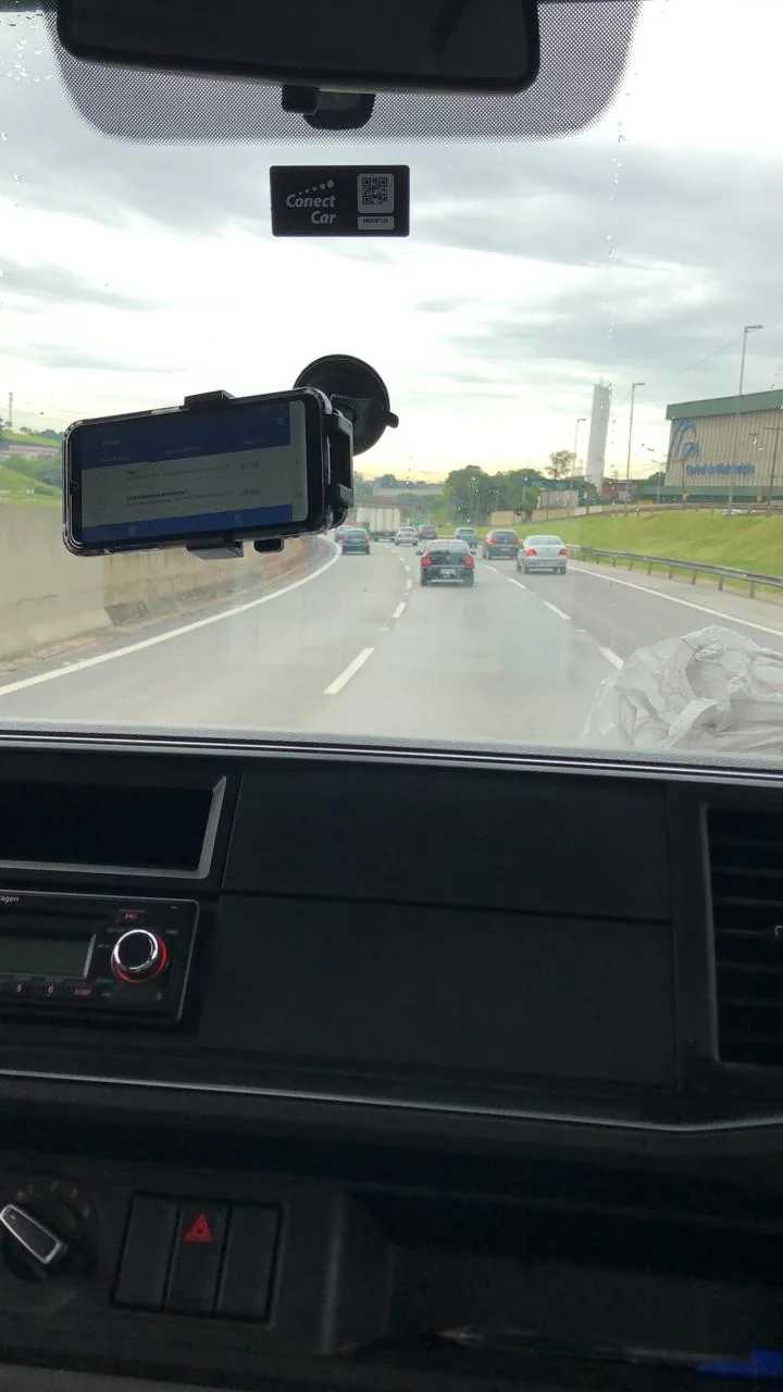 The app on a phone mounted on the windshield, on the highway