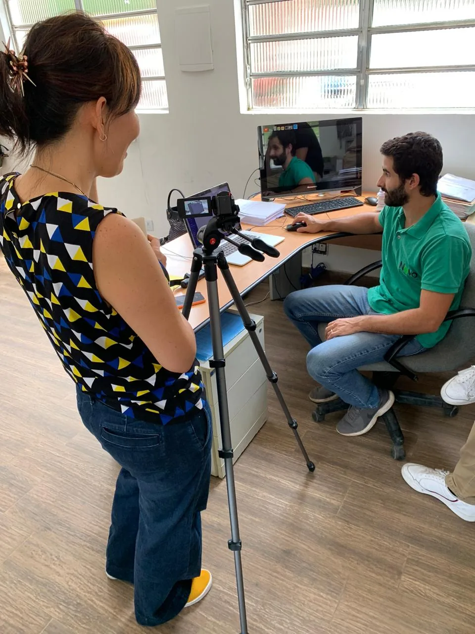 Usability test: a researcher films a participant at a desk as he goes through the prototype